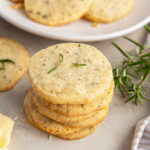 stack of savory shortbread cookies next to some fresh rosemary.