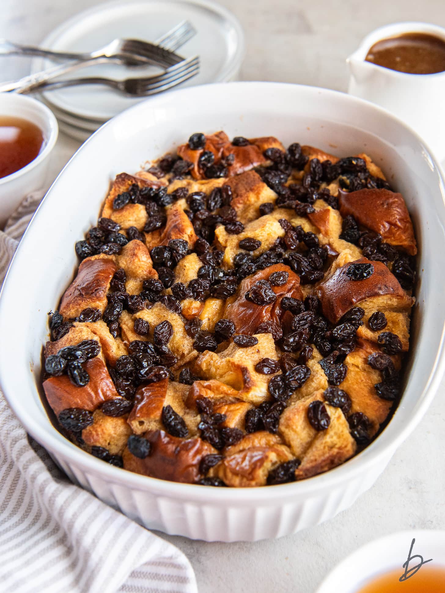 Irish bread pudding with raisins in a white baking dish.