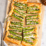 asparagus tart with puff pastry and gruyere cheese on a piece of parchment paper.