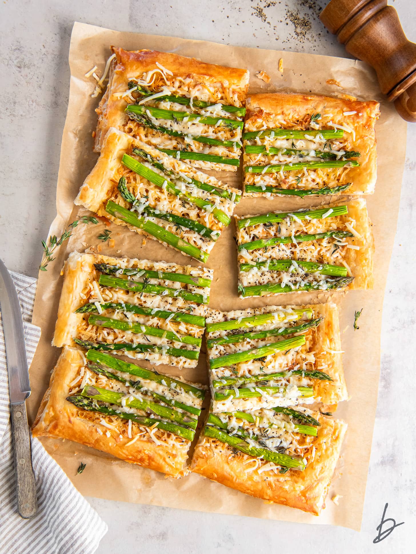 asparagus tart with puff pastry and gruyere cheese on a piece of parchment paper.