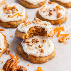 carrot cake cookie with a bite leaning on top of another cookie.