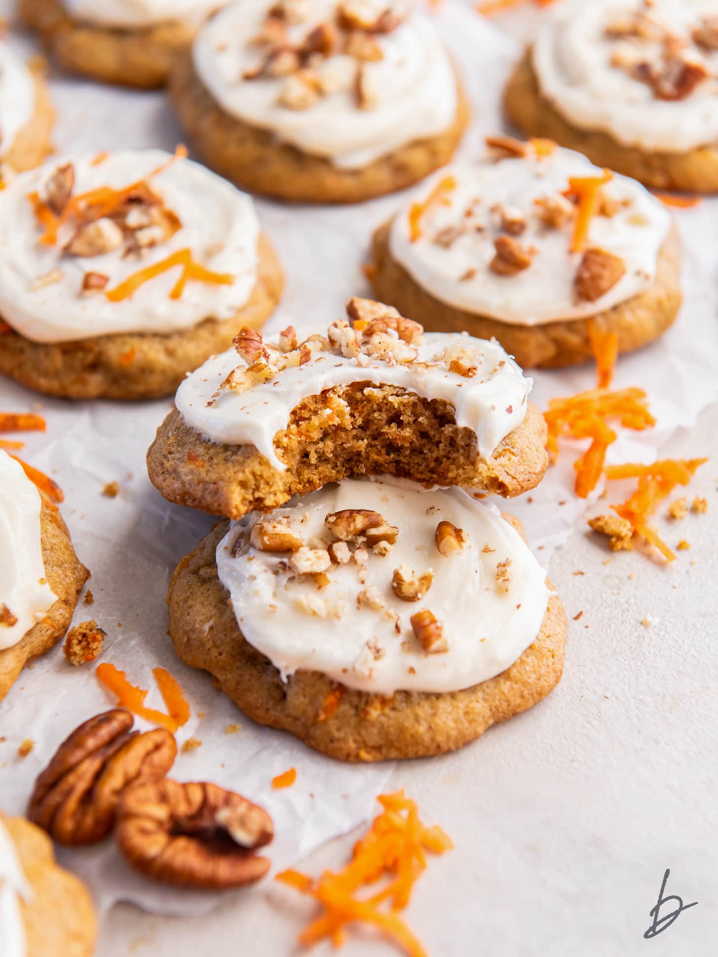 carrot cake cookie with a bite leaning on top of another cookie.