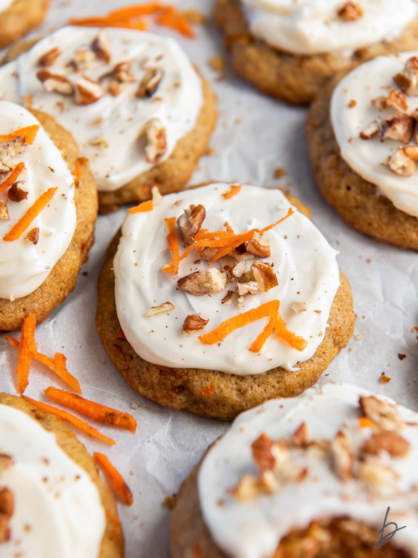 carrot cake cookie with cream cheese frosting and walnut garnish.