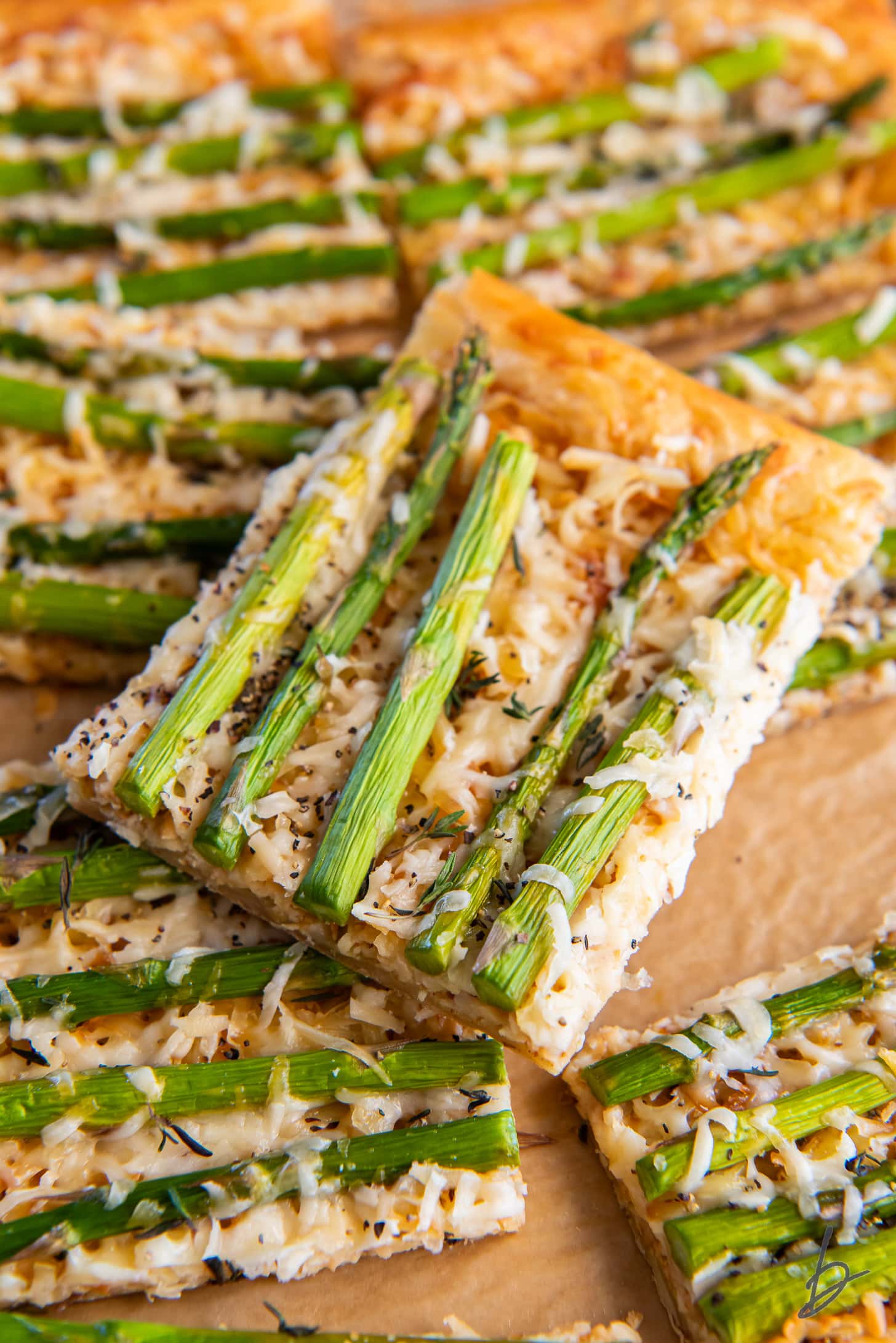 square slice of asparagus tart on top of more slices.