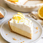slice of lemon icebox pie with whipped cream and lemon slice garnish on a plate.