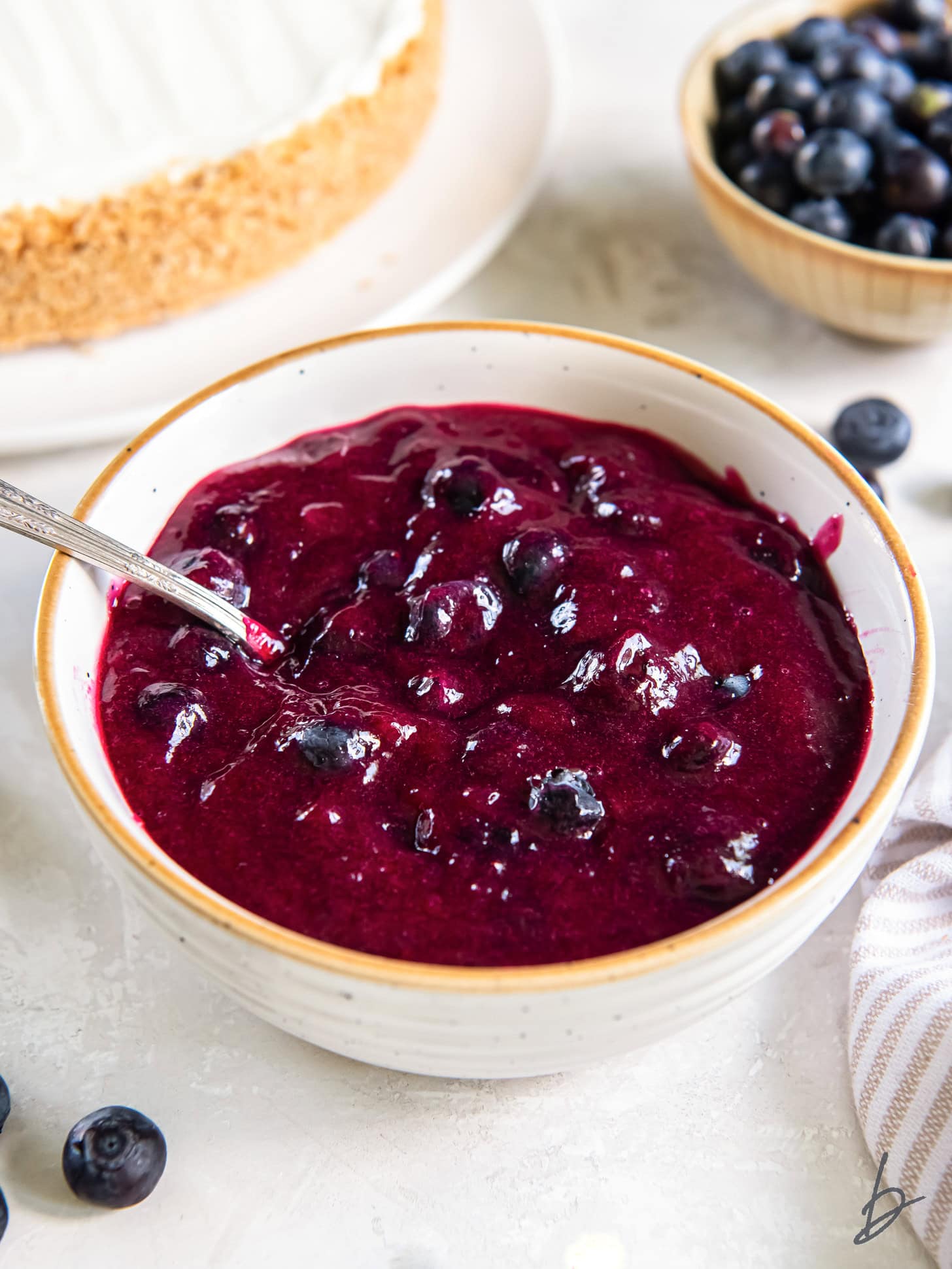 homemade blueberry sauce in a bowl with a spoon.