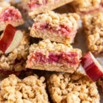 rhubarb crumble bar showing layers of crumb and filling leaning on another bar.