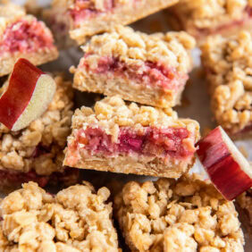 rhubarb crumble bar showing layers of crumb and filling leaning on another bar.