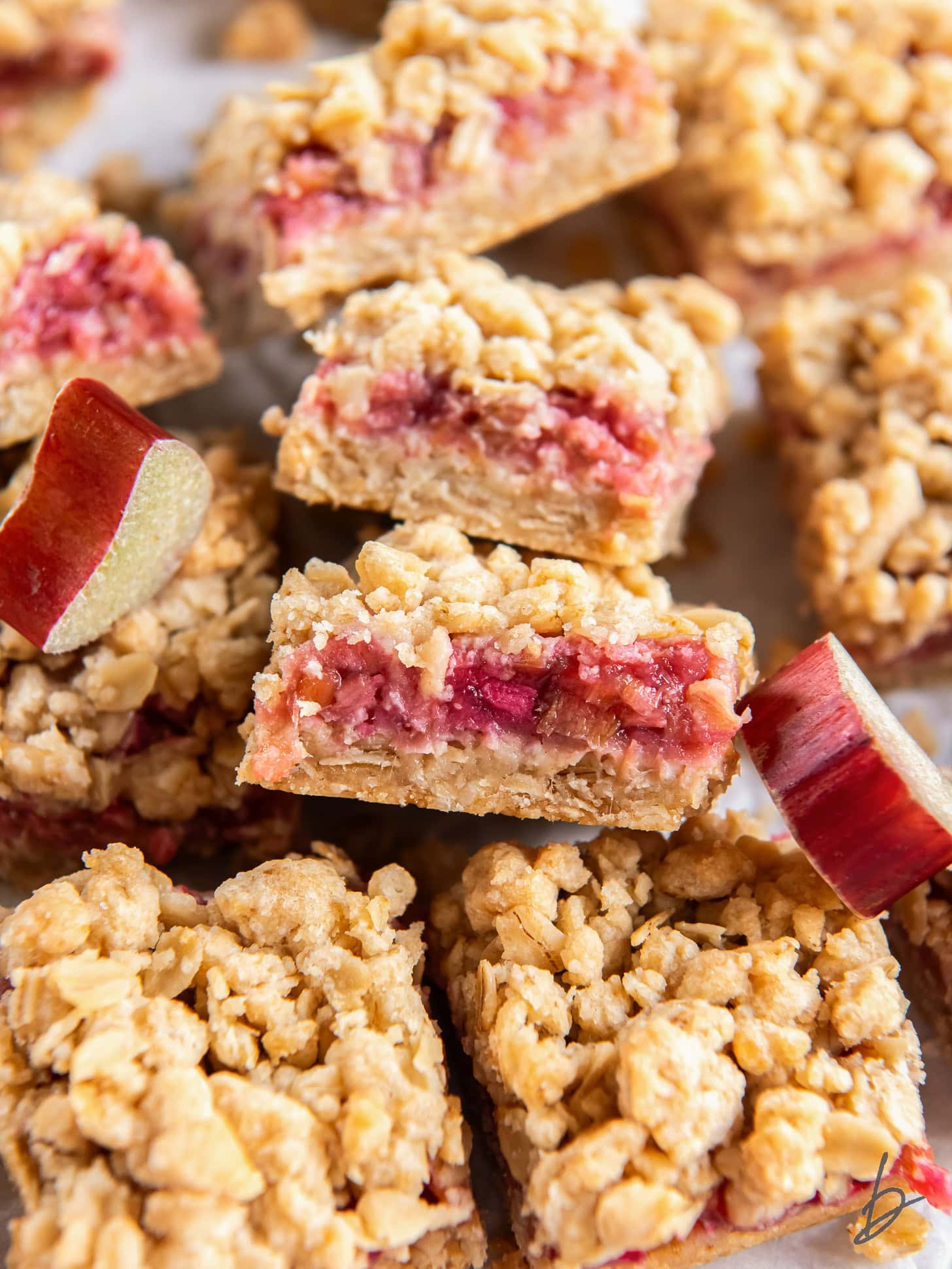 rhubarb crumble bar showing layers of crumb and filling leaning on another bar.