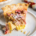 rhubarb custard pie slice with a fork taking a bite.