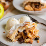 slice of apple strudel on a plate with vanilla ice cream.