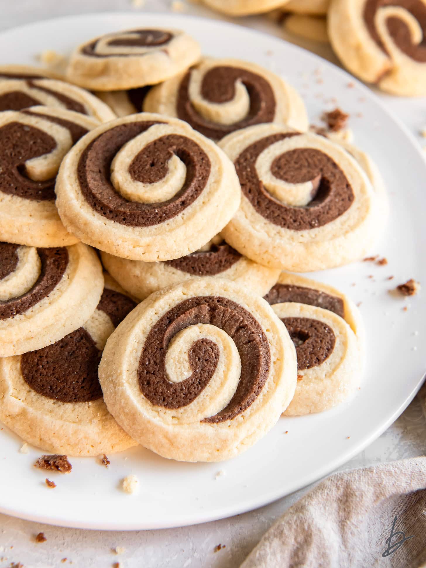 plate of chocolate pinwheel cookies in a pile.
