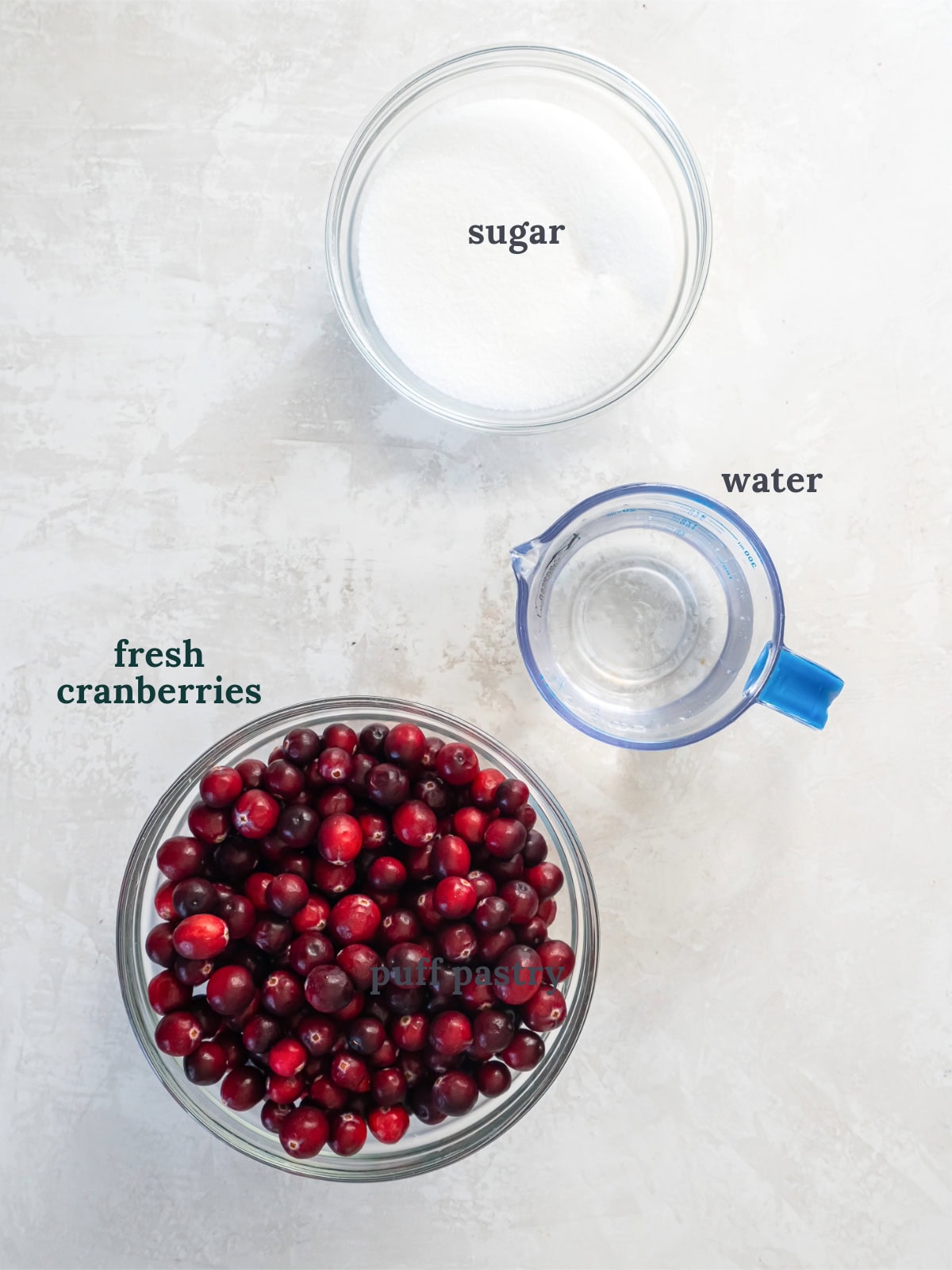 tabletop with bowls of ingredients to make sugared cranberries.
