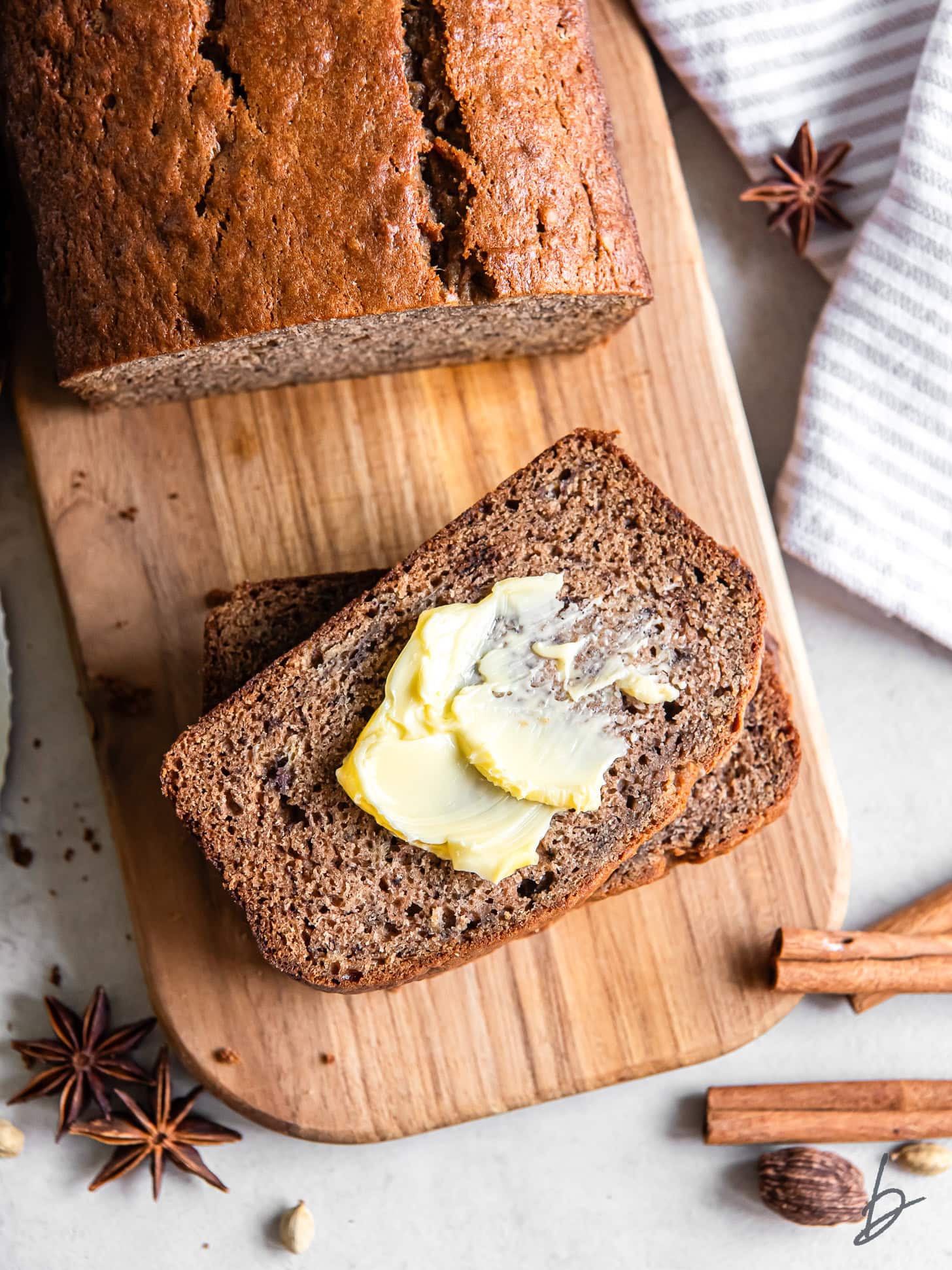 small cutting board with slice of chai banana bread with a little butter on it.