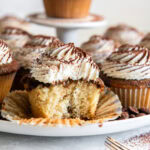A bite out of a frosted Tiramisu cupcake.