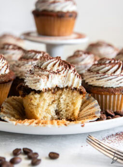 A bite out of a frosted Tiramisu cupcake.