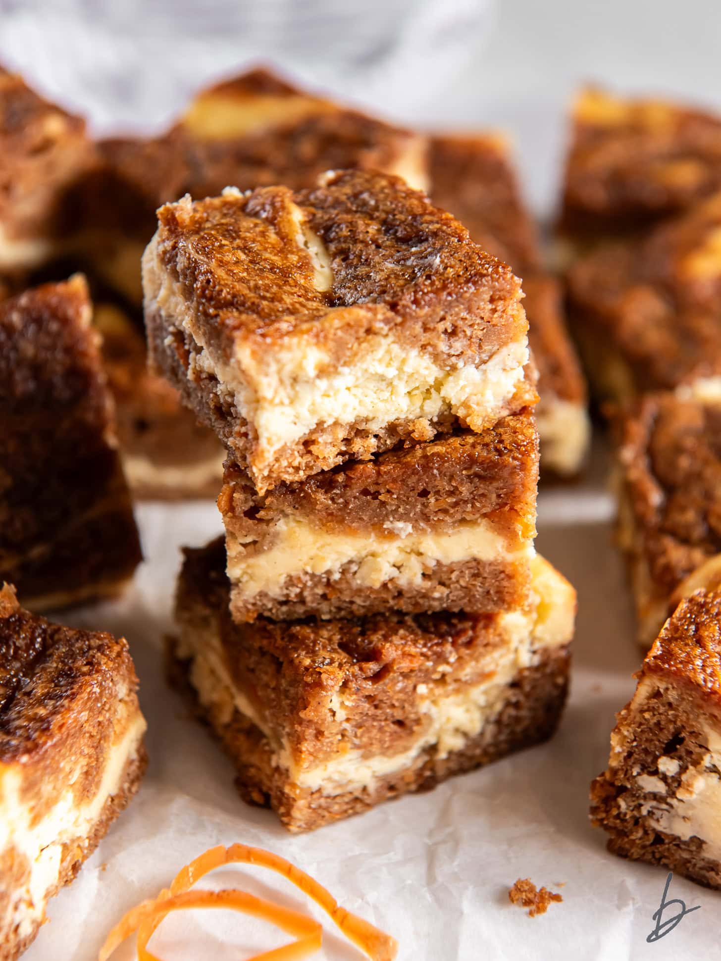 Carrot cake cheesecake bars stacked on each other.