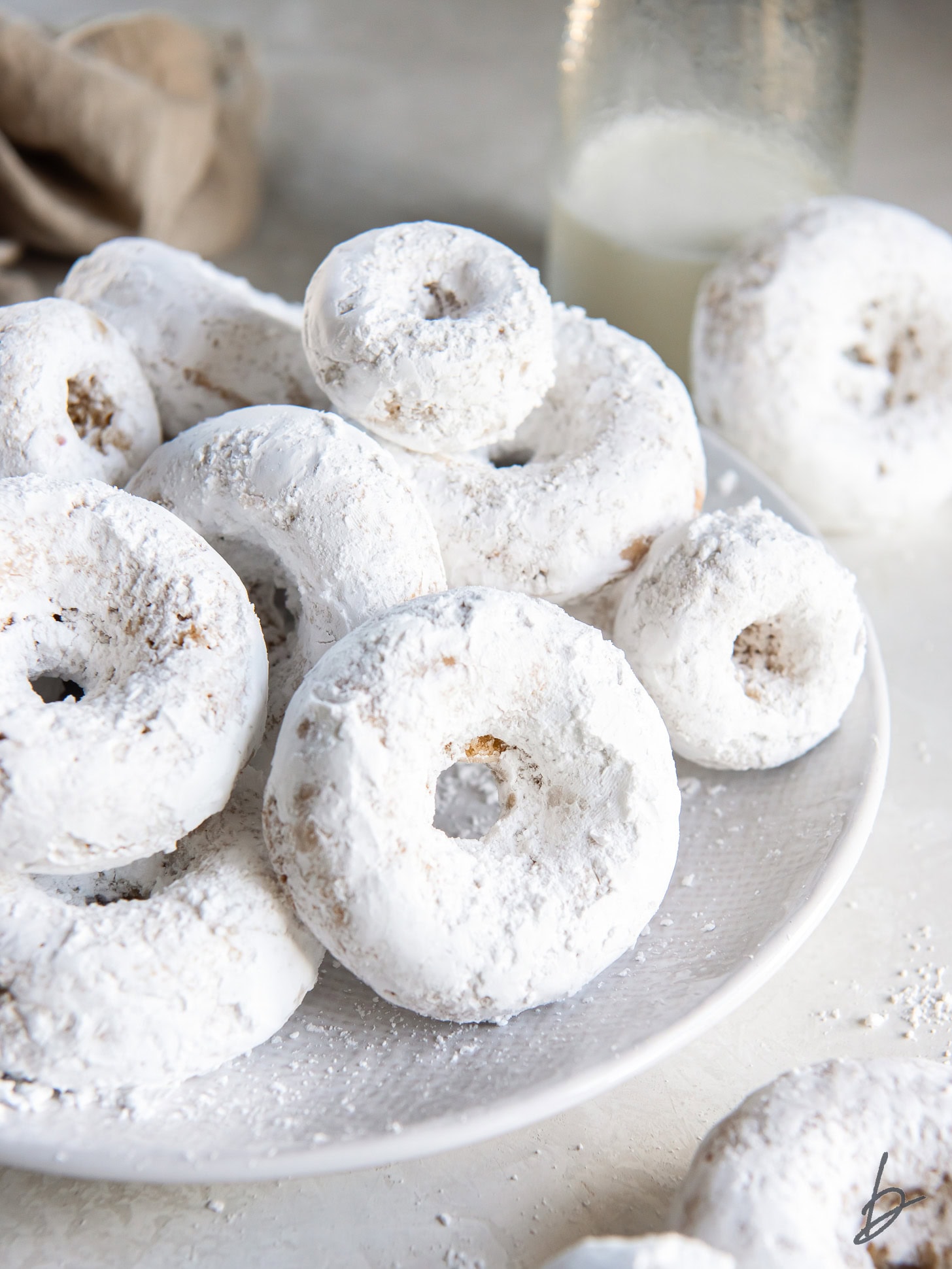 plate of homemade powdered sugar donuts.