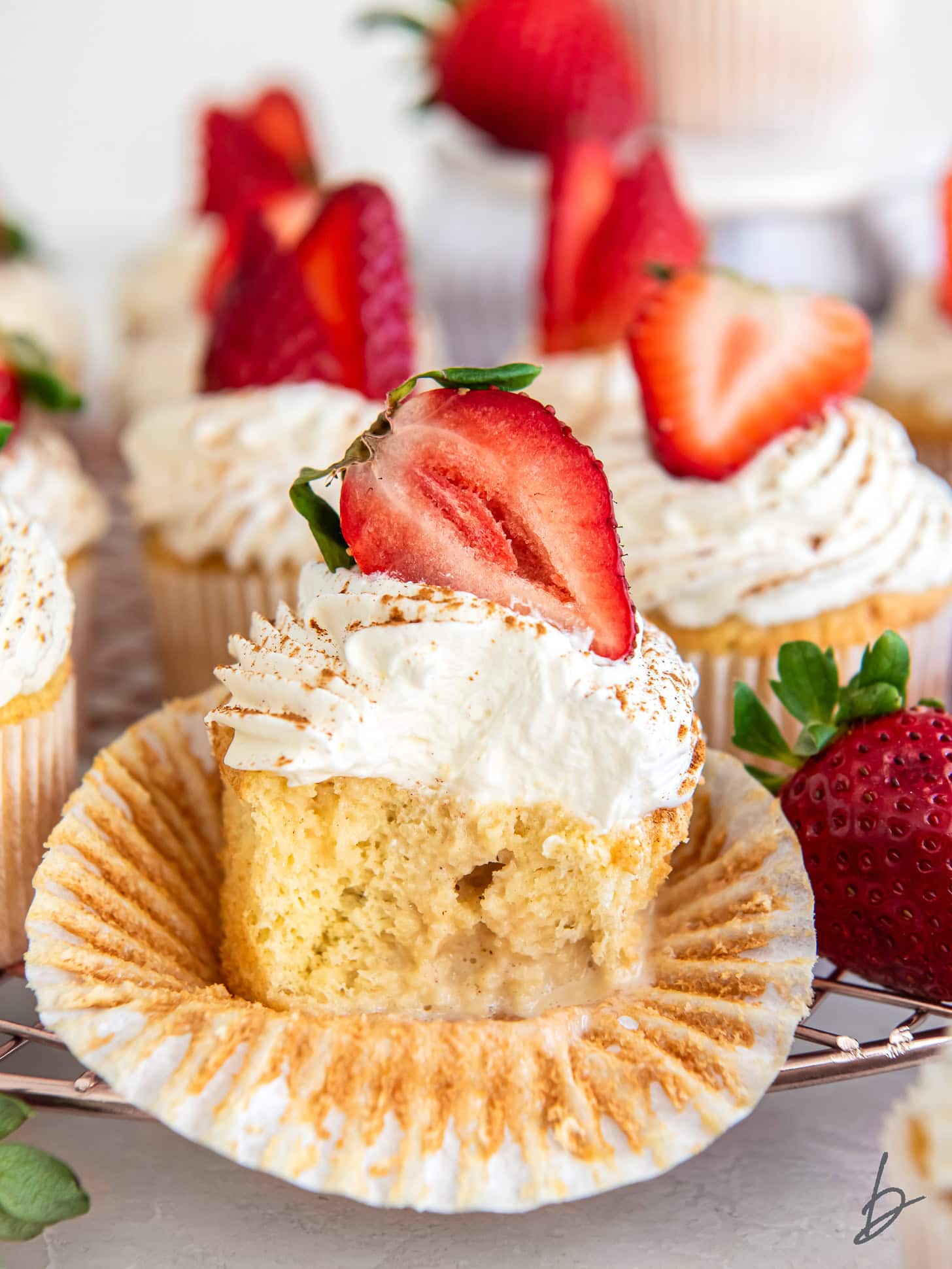 tres leches cupcake cut in half to show milk soaked filling.