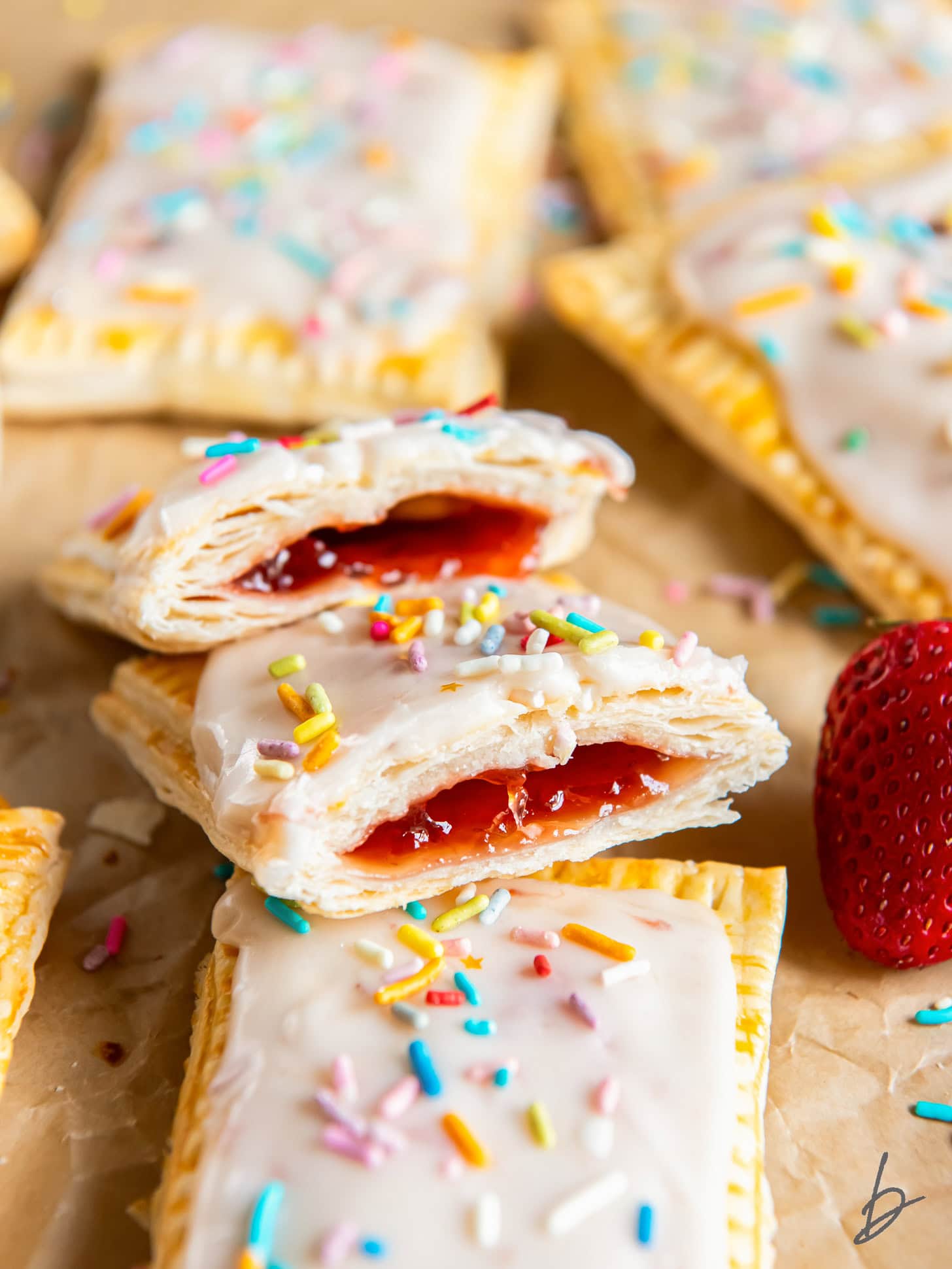 strawberry pop tart cut in half leaning on another pop tart with sprinkles.