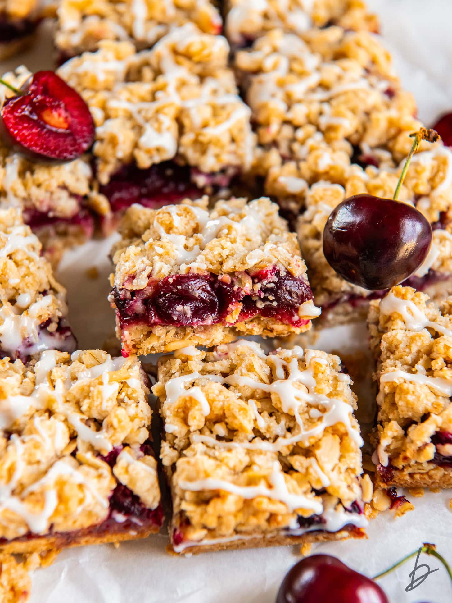 cherry pie bar leaning on other bars showing layers of crust, filling and crumble.