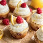 Lemon raspberry cupcakes garnished with a raspberry and slice of lemon.