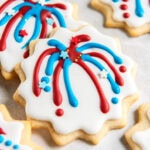 firework cookie with red and blue firework decoration leaning on top of another cookie.