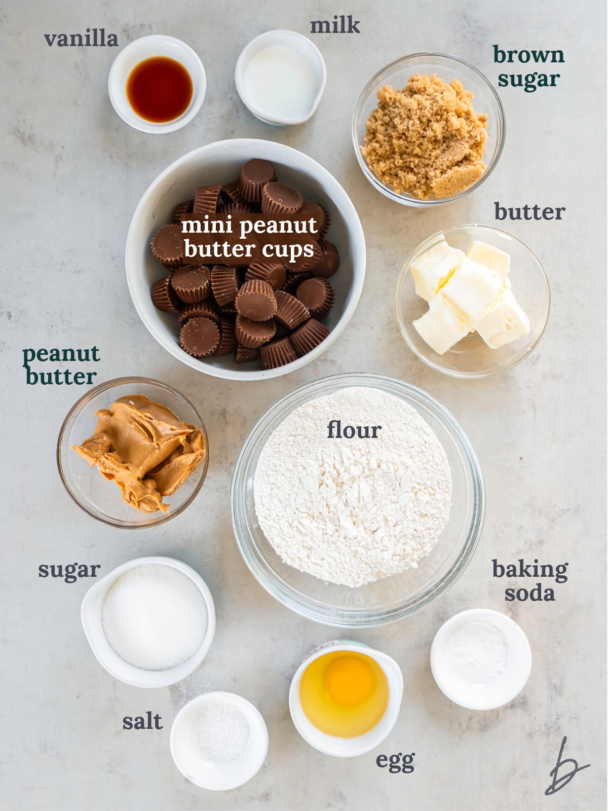 tabletop with bowls of ingredients to make peanut butter cup cookies.