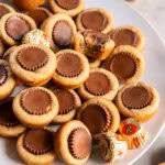 plate with mini peanut butter cup cookies some more cookies with peanut butter cups pressed into the center.a