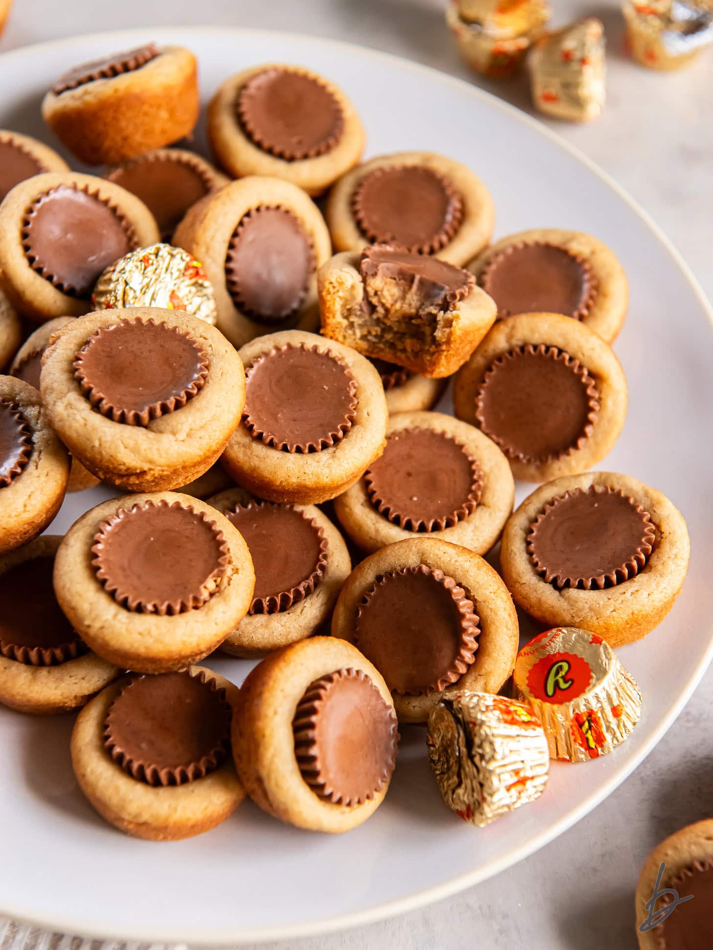 plate with mini peanut butter cup cookies some more cookies with peanut butter cups pressed into the center.a
