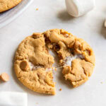 fluffernutter cookie pulled in half with gooey marshmallow and set on a tabletop surface.