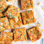 birthday cake blondies with sprinkles on parchment paper.