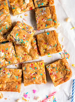 birthday cake blondies with sprinkles on parchment paper.