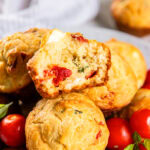 Stacked tomato muffins with a bite out of one.