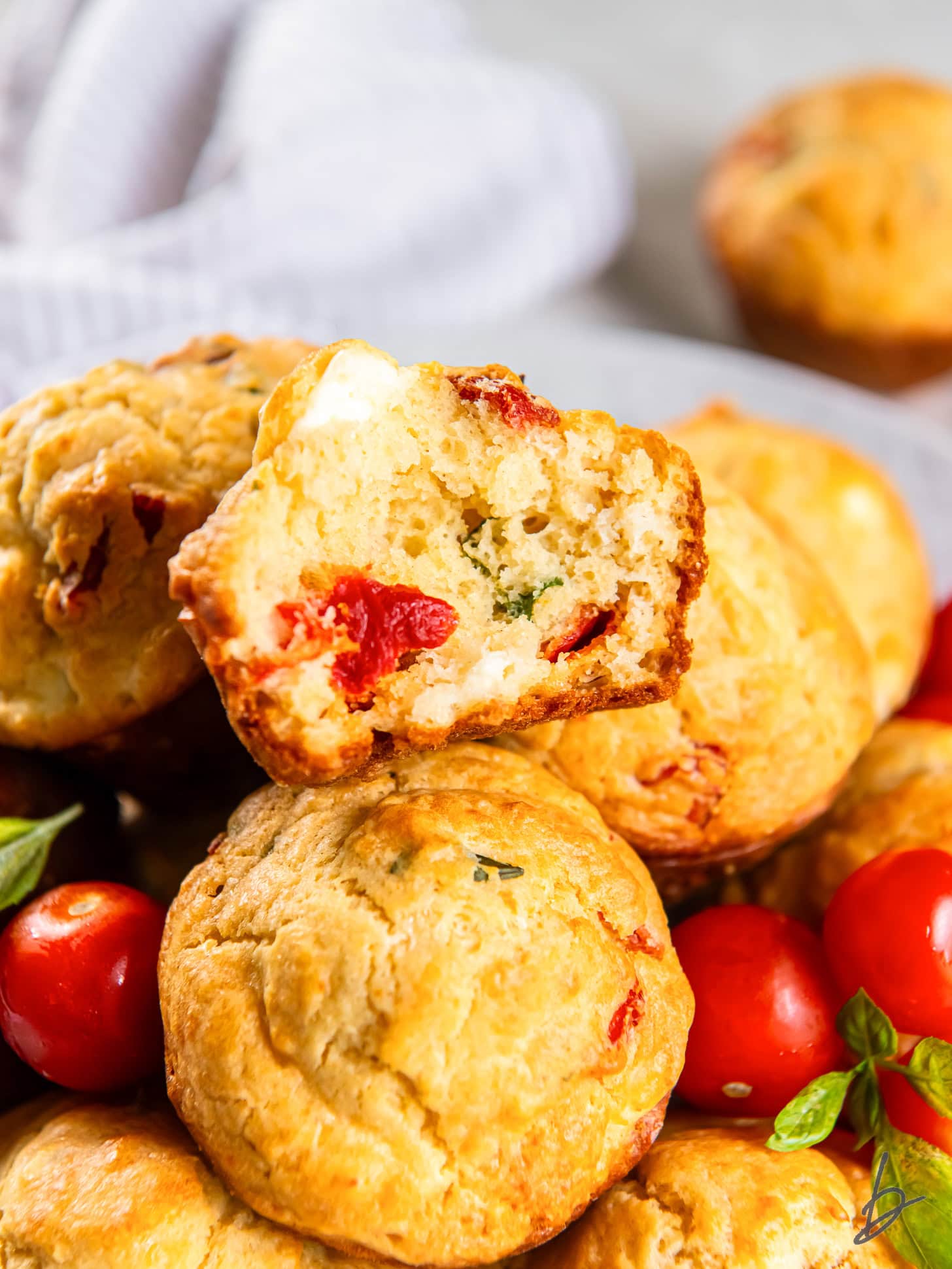 Stacked tomato muffins with a bite out of one.