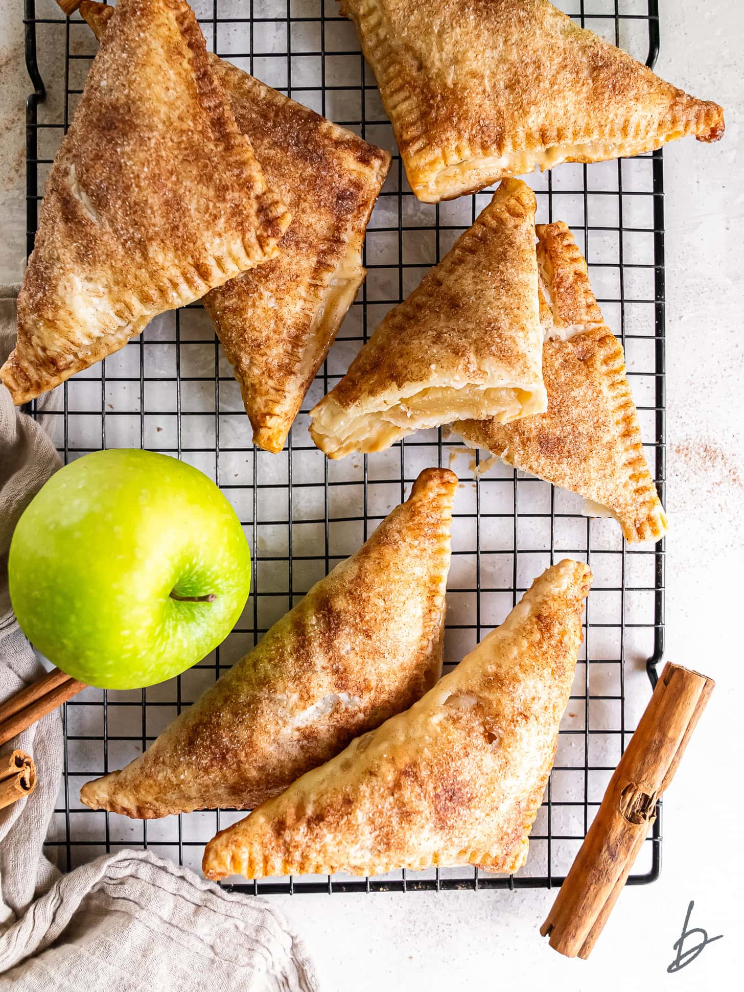 Puff pastry apple turnovers on a wire rack.