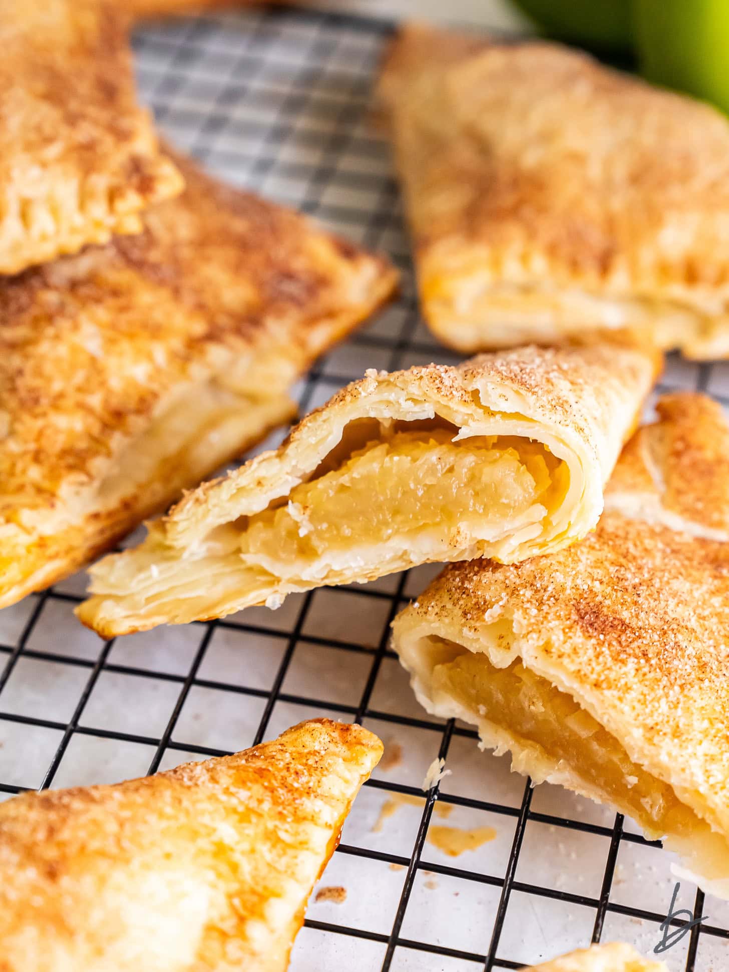 Apple turnovers on a wire cooling rack.