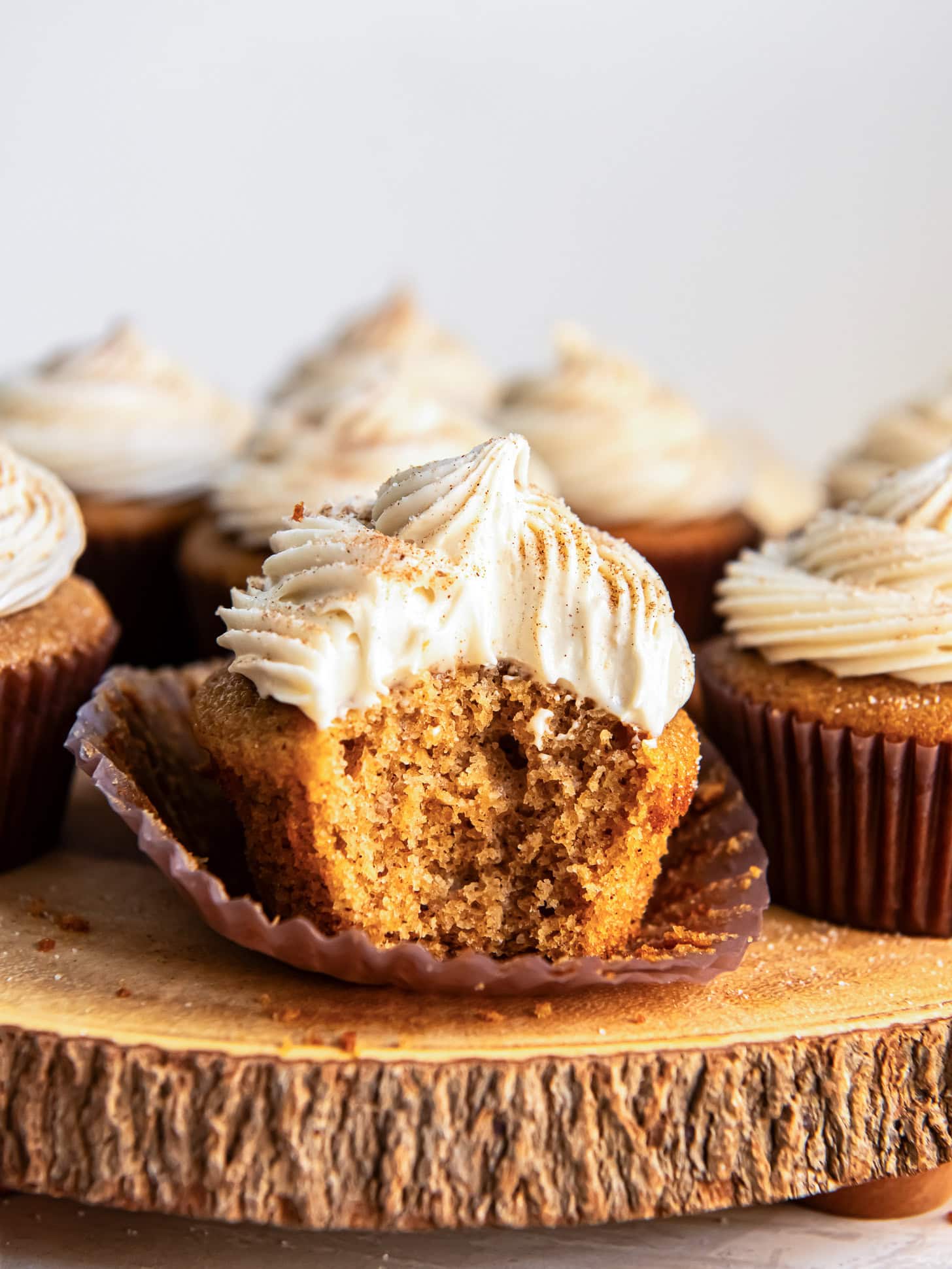 Spice cake cupcakes with a bite taken out of one.