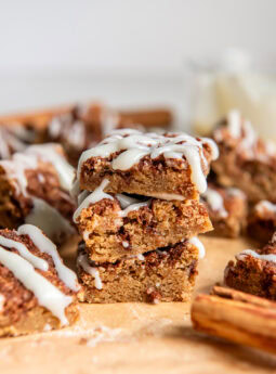 stack of three cinnamon roll blondies in front of more blondies.