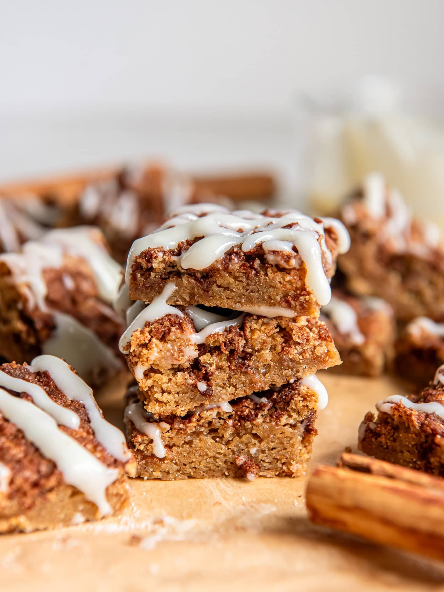 stack of three cinnamon roll blondies in front of more blondies.