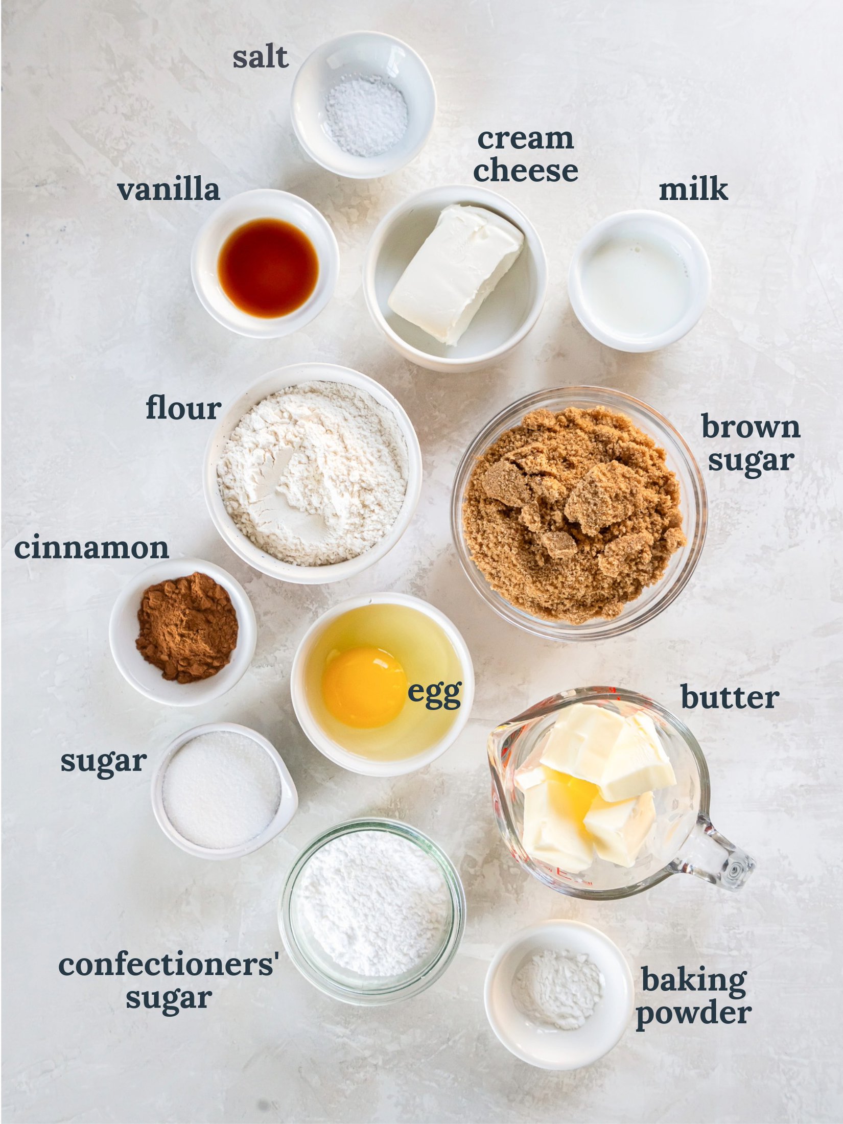 tabletop with bowls of ingredients to make cinnamon roll blondies.