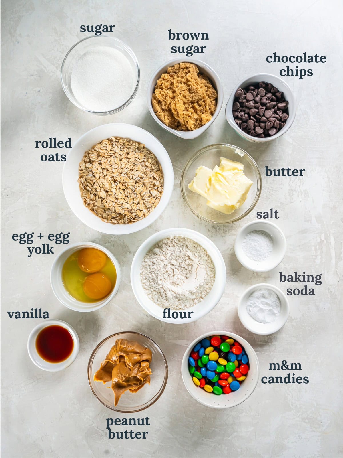 tabletop with bowls of ingredients to make monster cookies.