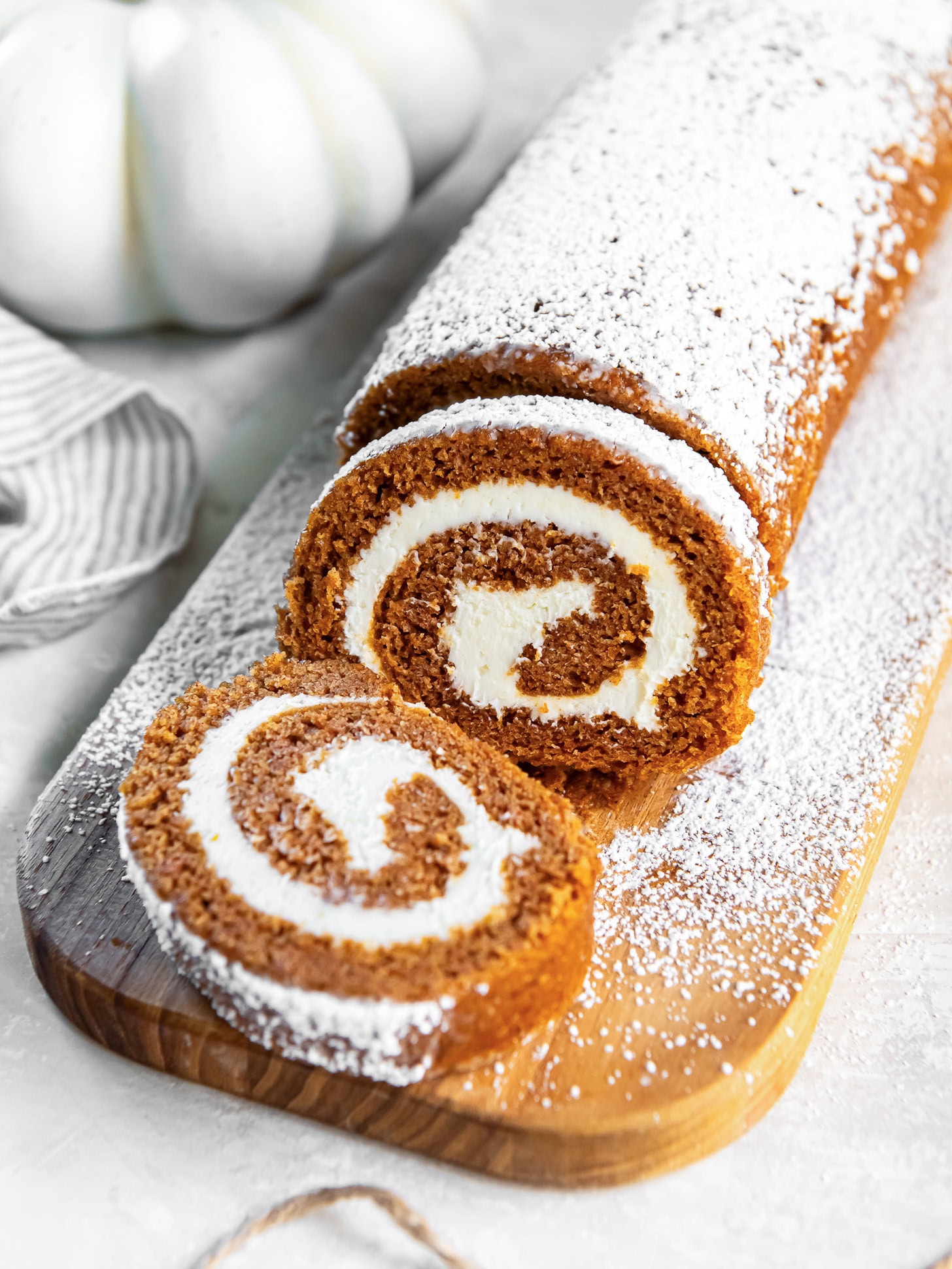 Sliced pumpkin roll cake dusted with powdered sugar.