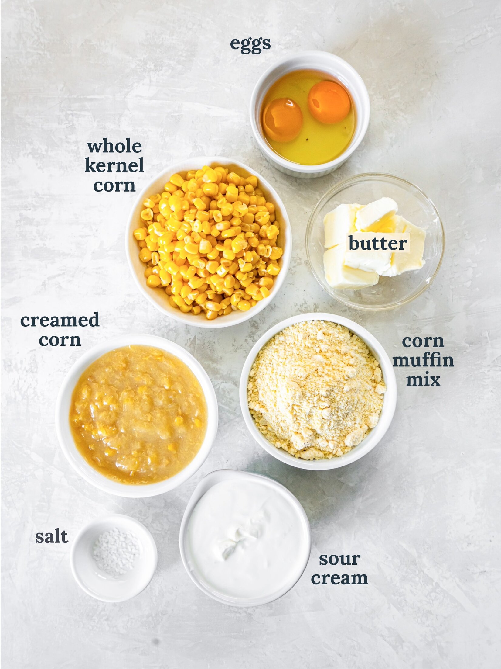 Small bowls with corn, eggs, butter, corn muffin mix and sour cream.