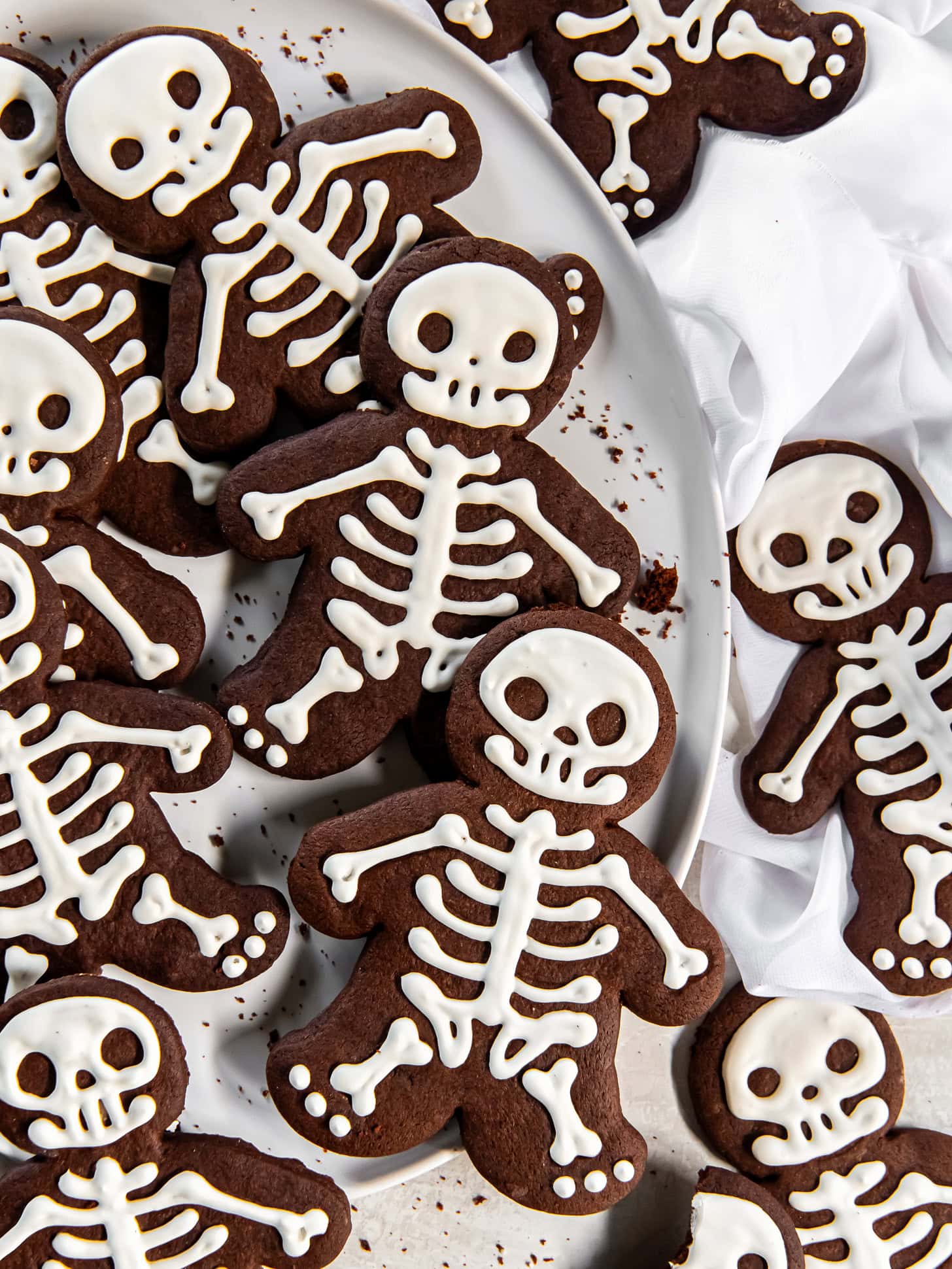Halloween skeleton cookies on a white plate.
