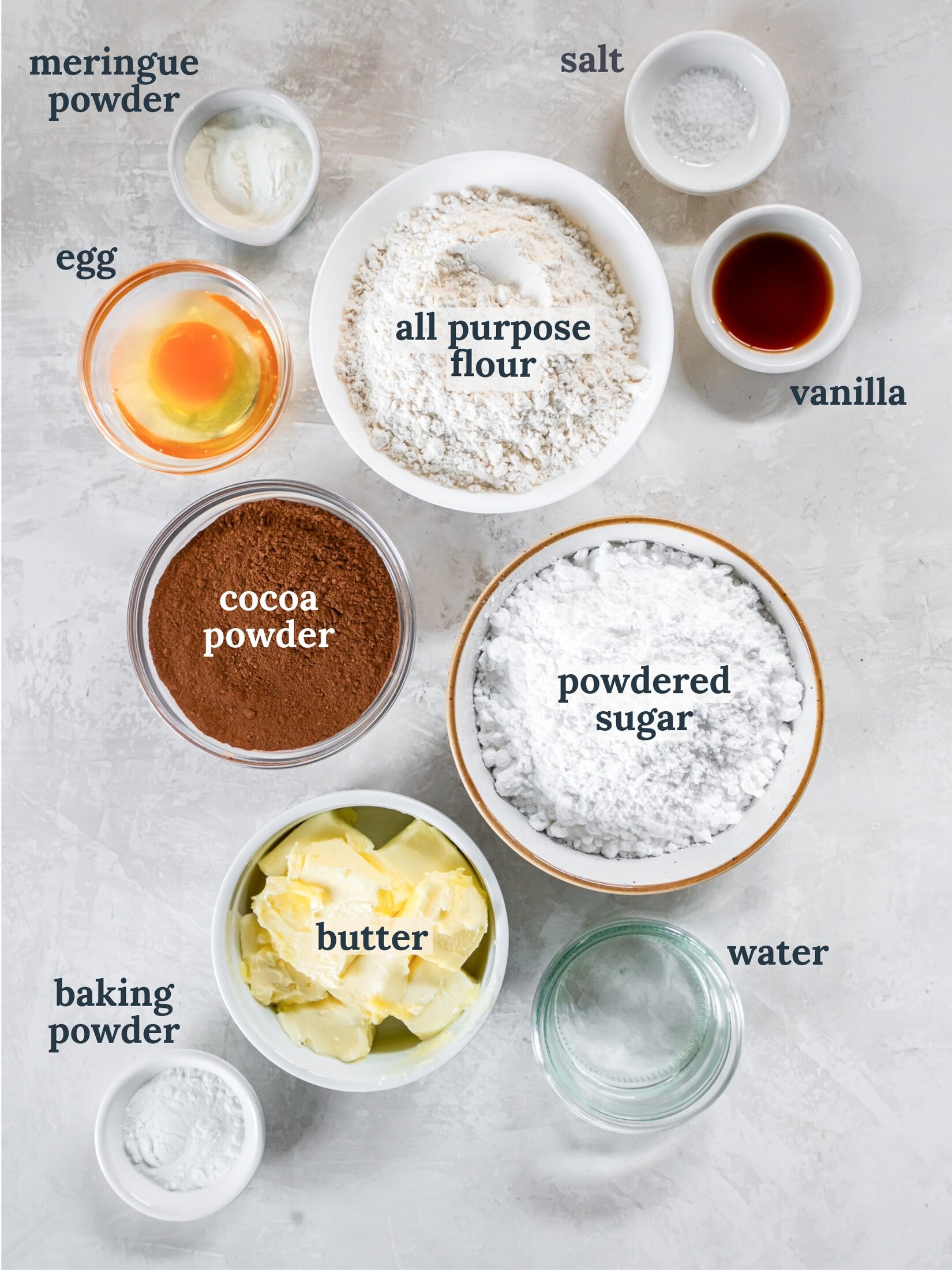 Small bowls with flour, powdered sugar, cocoa powder, butter and vanilla.