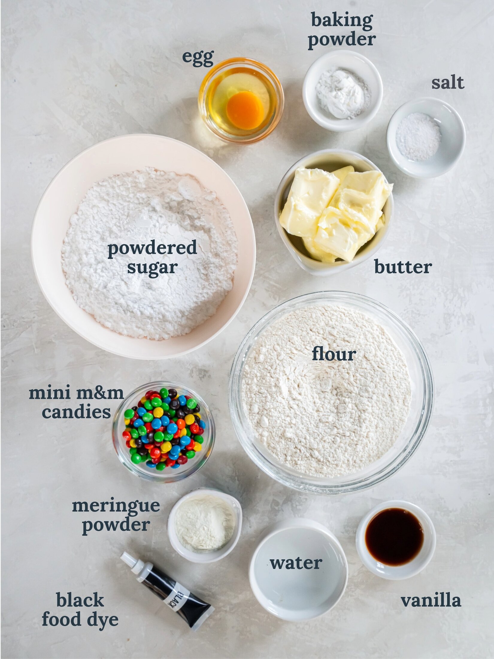 Bowls of four, powdered sugar, butter, water, egg, and candy.