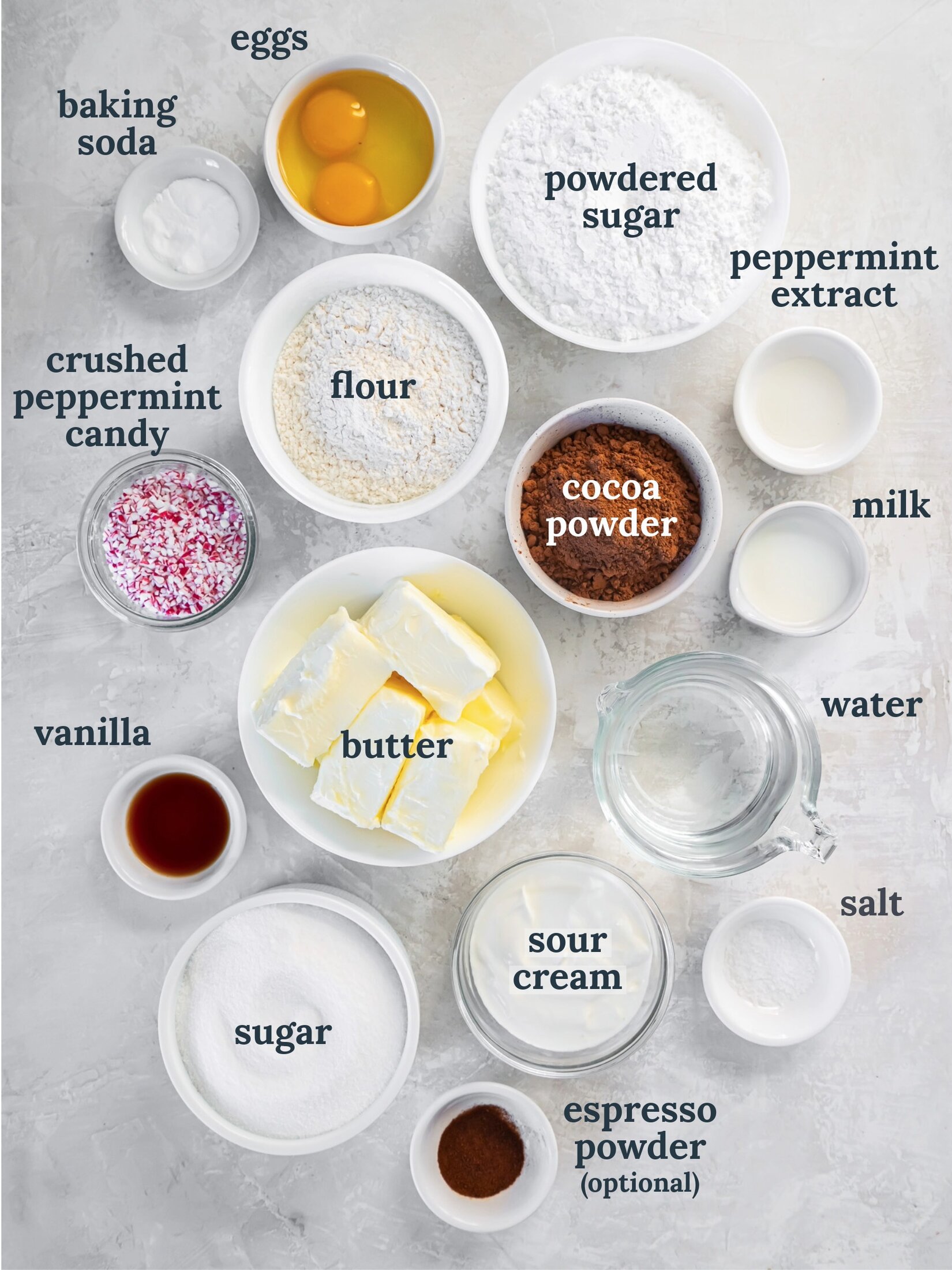 Small bowls with butter, flour, powdered sugar, cocoa powder, sour cream and crushed peppermint candy.