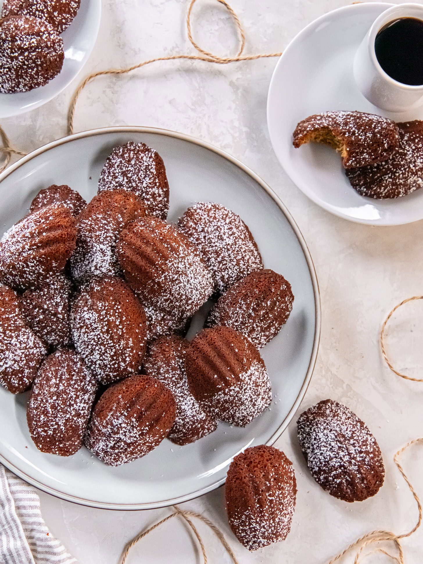 Gingerbread madeleines served with coffee on a white plate.