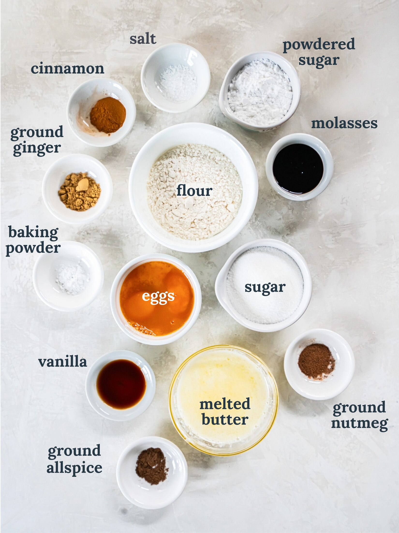 Small bowls with flour, eggs, melted butter, vanilla and spices.